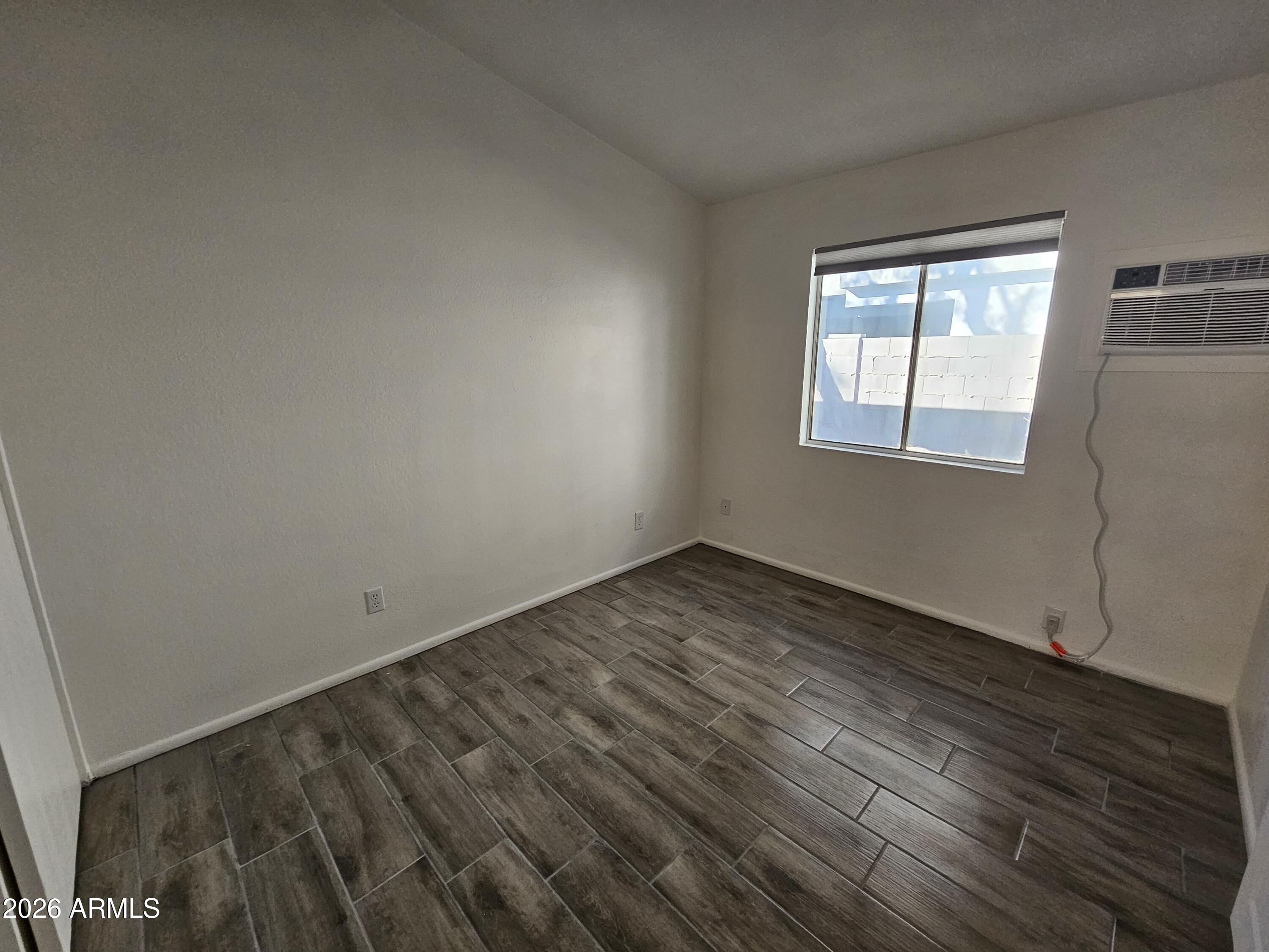302 South Westfall Avenue, Unit 2 Tempe, AZ 85281 - Photo 8 of 19 an empty room with wooden floor and windows