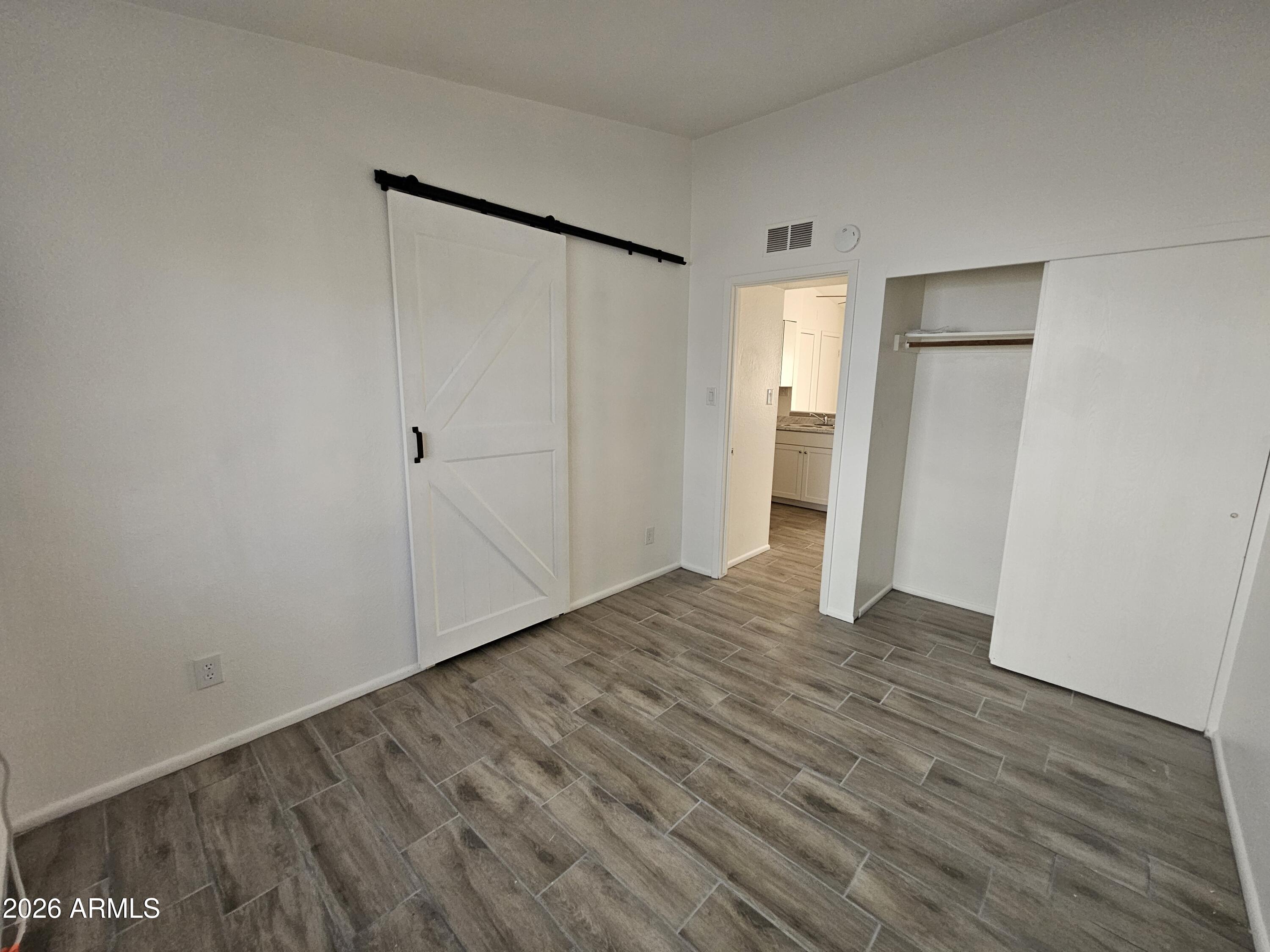 302 South Westfall Avenue, Unit 2 Tempe, AZ 85281 - Photo 9 of 19 a view of an empty room with wooden floor and a bathroom