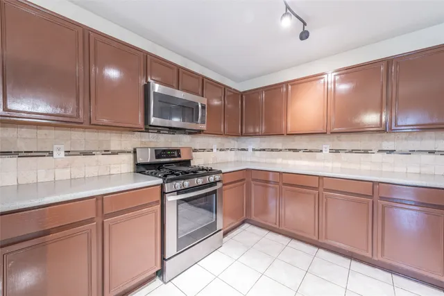 a kitchen with granite countertop cabinets stainless steel appliances a sink and a counter space