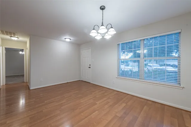 a view of a livingroom with a chandelier fan and windows