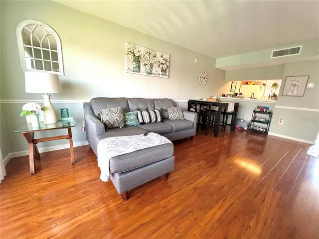 a living room with furniture and a wooden floor