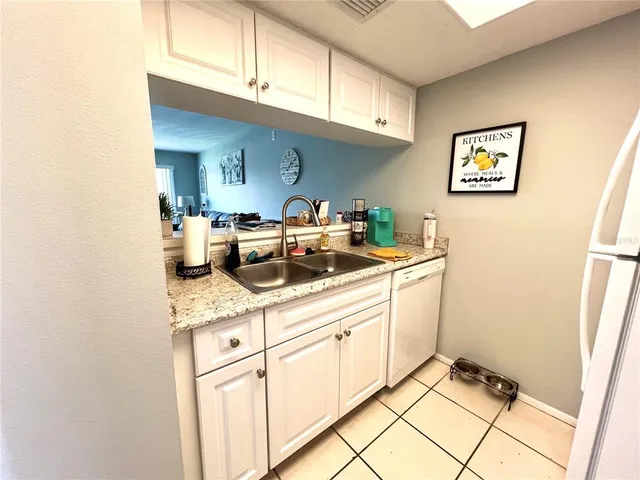 a kitchen with white cabinets and sink