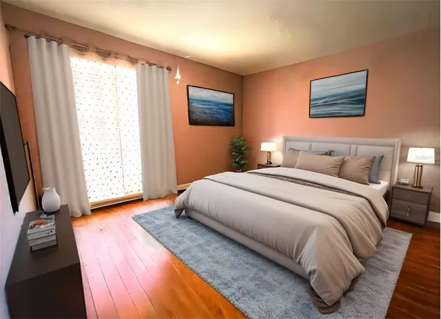 a bedroom with a large bed and a flat tv screen