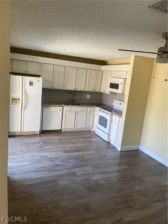 a view of a kitchen with wooden floor and electronic appliances