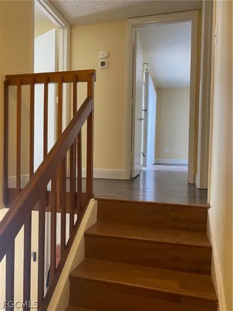 a view of staircase with lots of frames on wall and wooden floor