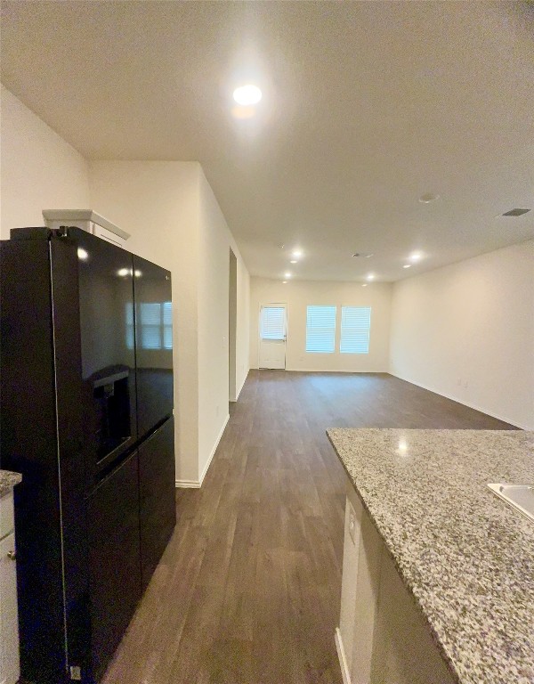 19101 Romano Drive Elgin, TX 78621 - Photo 13 of 36 a view of a hallway to an empty room and wooden floor