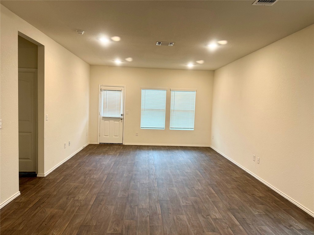 19101 Romano Drive Elgin, TX 78621 - Photo 17 of 36 an empty room with wooden floor and windows