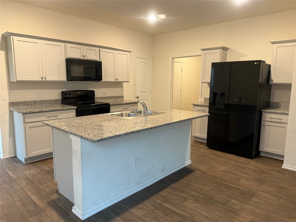19101 Romano Drive Elgin, TX 78621 - Photo 8 of 36 a kitchen with a refrigerator and a stove top oven