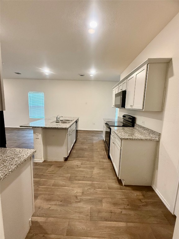 19101 Romano Drive Elgin, TX 78621 - Photo 10 of 36 a room with kitchen island stainless steel appliances a sink a stove top oven a counter space and cabinets