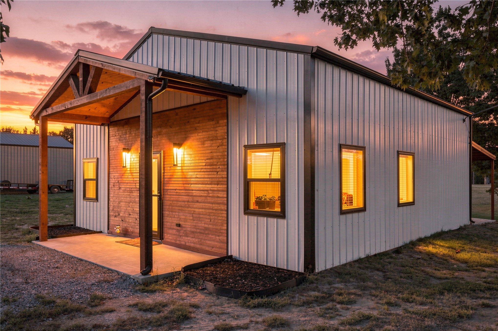 420942 East 1168 Road Eufaula, OK 74432 - Photo 10 of 43 Corrugated metal siding with wood-finish accent paneling, covered entry porch with exposed wood beams, concrete patio, and exterior lighting fixtures