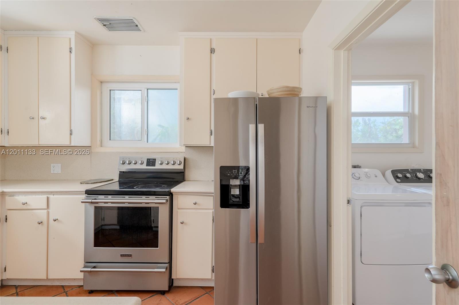 55 North Beach Road Jupiter Island, FL 33455 - Photo 51 of 56 a kitchen with stainless steel appliances white cabinets and a refrigerator