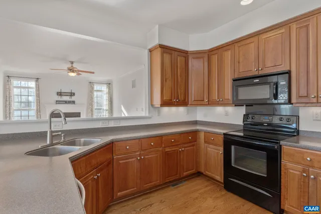a kitchen with granite countertop a sink stainless steel appliances and cabinets