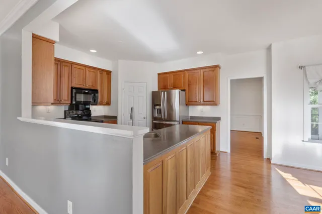a kitchen with stainless steel appliances granite countertop a refrigerator and a stove top oven