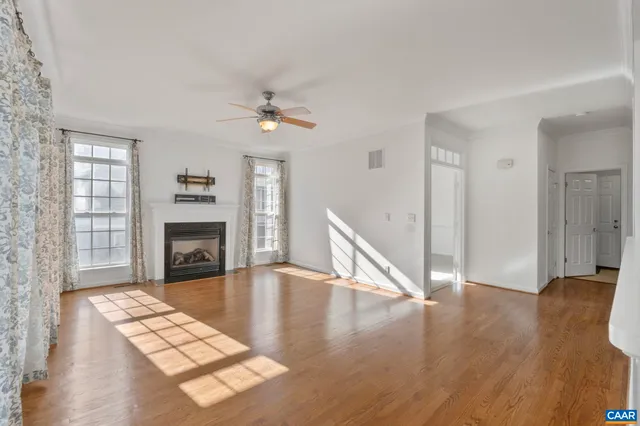 a view of a livingroom with wooden floor and a fireplace