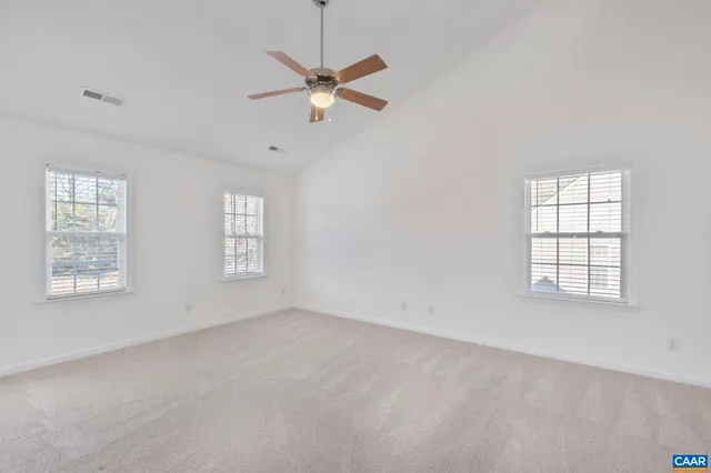 an empty room with windows and fan
