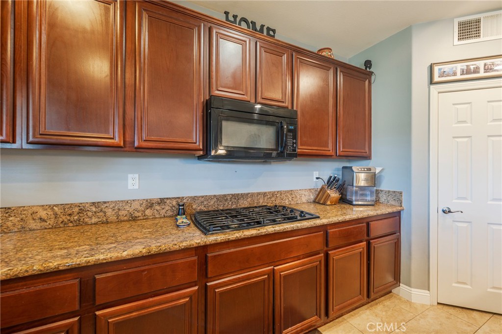 17073 Spring Canyon Place Riverside, CA 92503 - Photo 11 of 43 a kitchen with granite countertop cabinets and stainless steel appliances