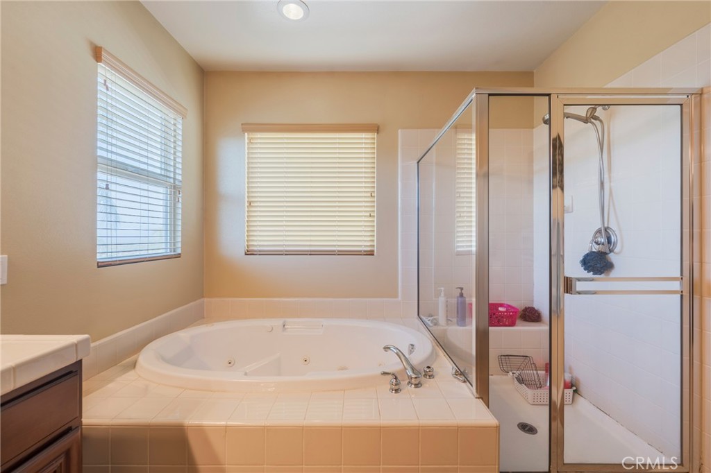 17073 Spring Canyon Place Riverside, CA 92503 - Photo 18 of 43 a bathroom with a bathtub a shower and a window