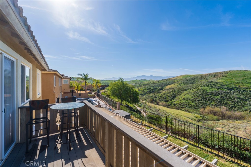 17073 Spring Canyon Place Riverside, CA 92503 - Photo 19 of 43 a view of a balcony with chairs and wooden fence
