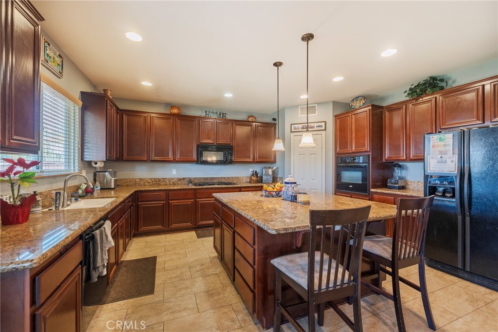 17073 Spring Canyon Place Riverside, CA 92503 - Photo 8 of 43 a kitchen with granite countertop a sink appliances and cabinets