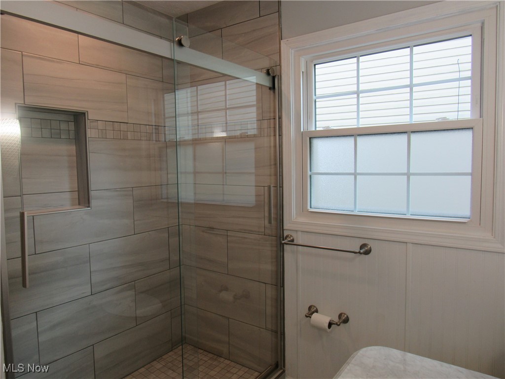 1120 Vincent Road Southeast North Canton, OH 44720 - Photo 27 of 50 Main Bathroom with a healthy amount of sunlight and a tile shower with shower door