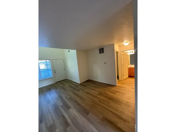 a view of empty room with wooden floor