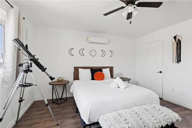 a bedroom with a bed and painting on the wall