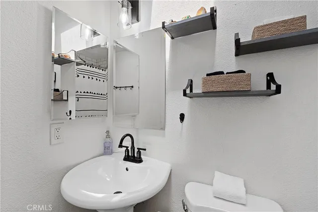 a bathroom with a sink a toilet and a mirror