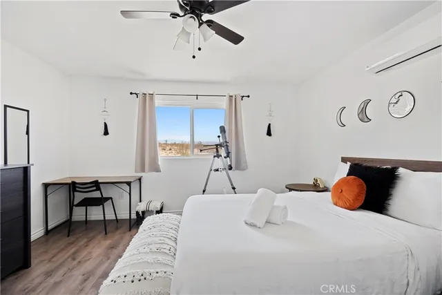 a bedroom with a bed and painting on the wall