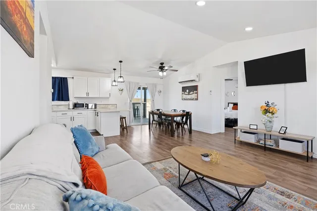 a kitchen with stainless steel appliances granite countertop a stove a sink a dining table and chairs with wooden floor