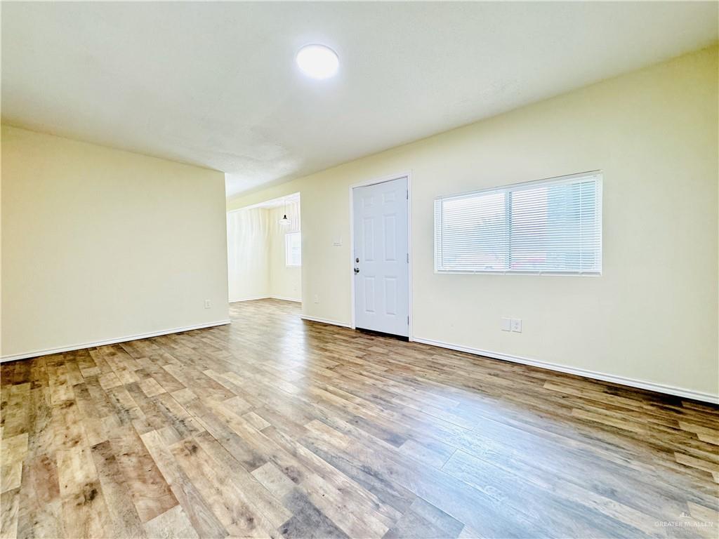 1620 West Samano Street Edinburg, TX 78539 - Photo 20 of 39 an empty room with wooden floor and windows