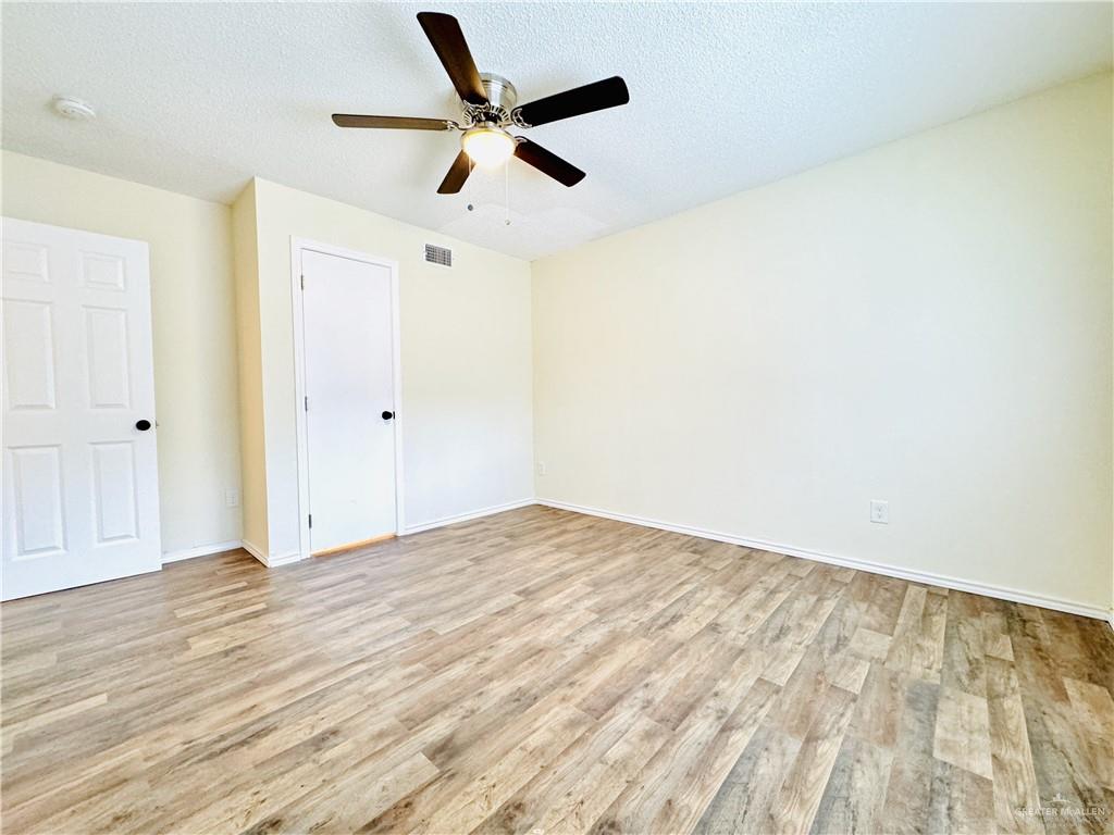 1620 West Samano Street Edinburg, TX 78539 - Photo 32 of 39 an empty room with wooden floor and ceiling fan