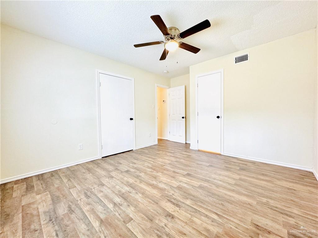 1620 West Samano Street Edinburg, TX 78539 - Photo 33 of 39 an empty room with wooden floor and ceiling fan