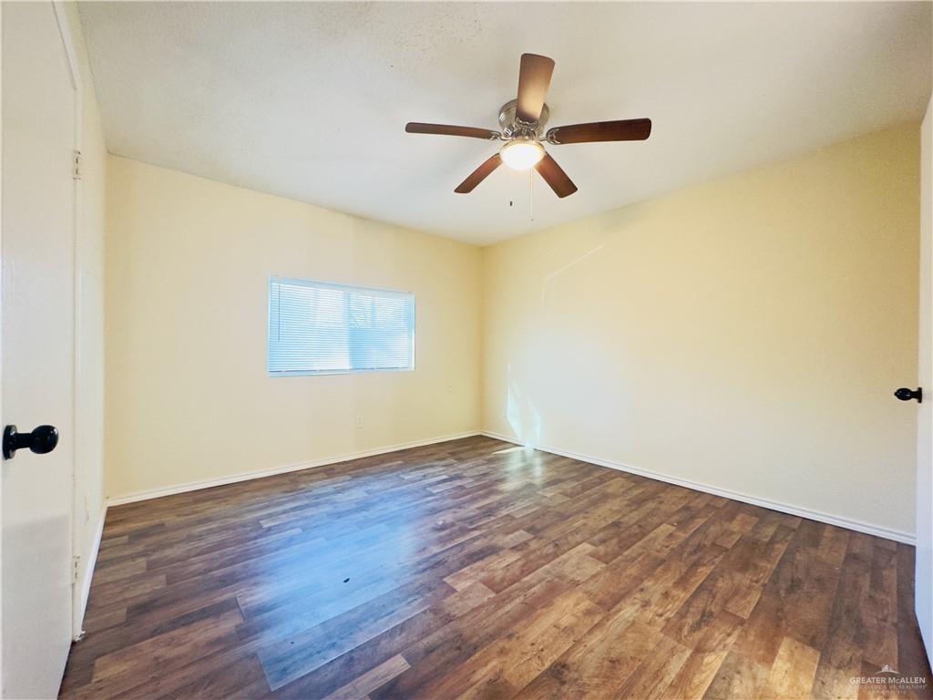 1620 West Samano Street Edinburg, TX 78539 - Photo 39 of 39 an empty room with wooden floor a ceiling fan and window