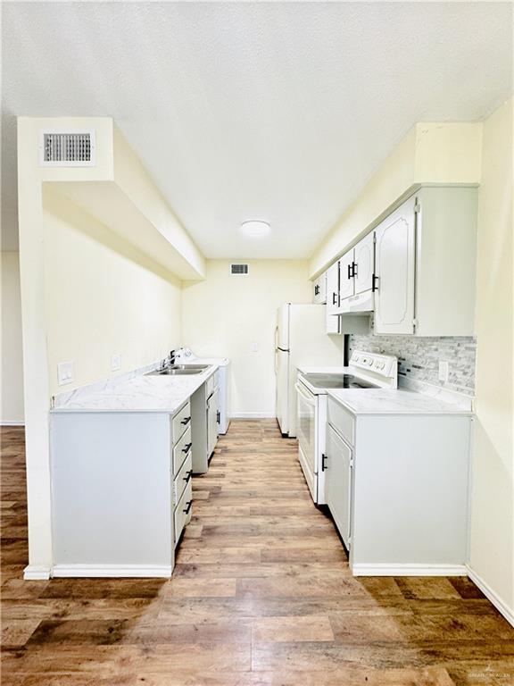 1620 West Samano Street Edinburg, TX 78539 - Photo 10 of 39 a large white kitchen with sink and white stainless steel appliances