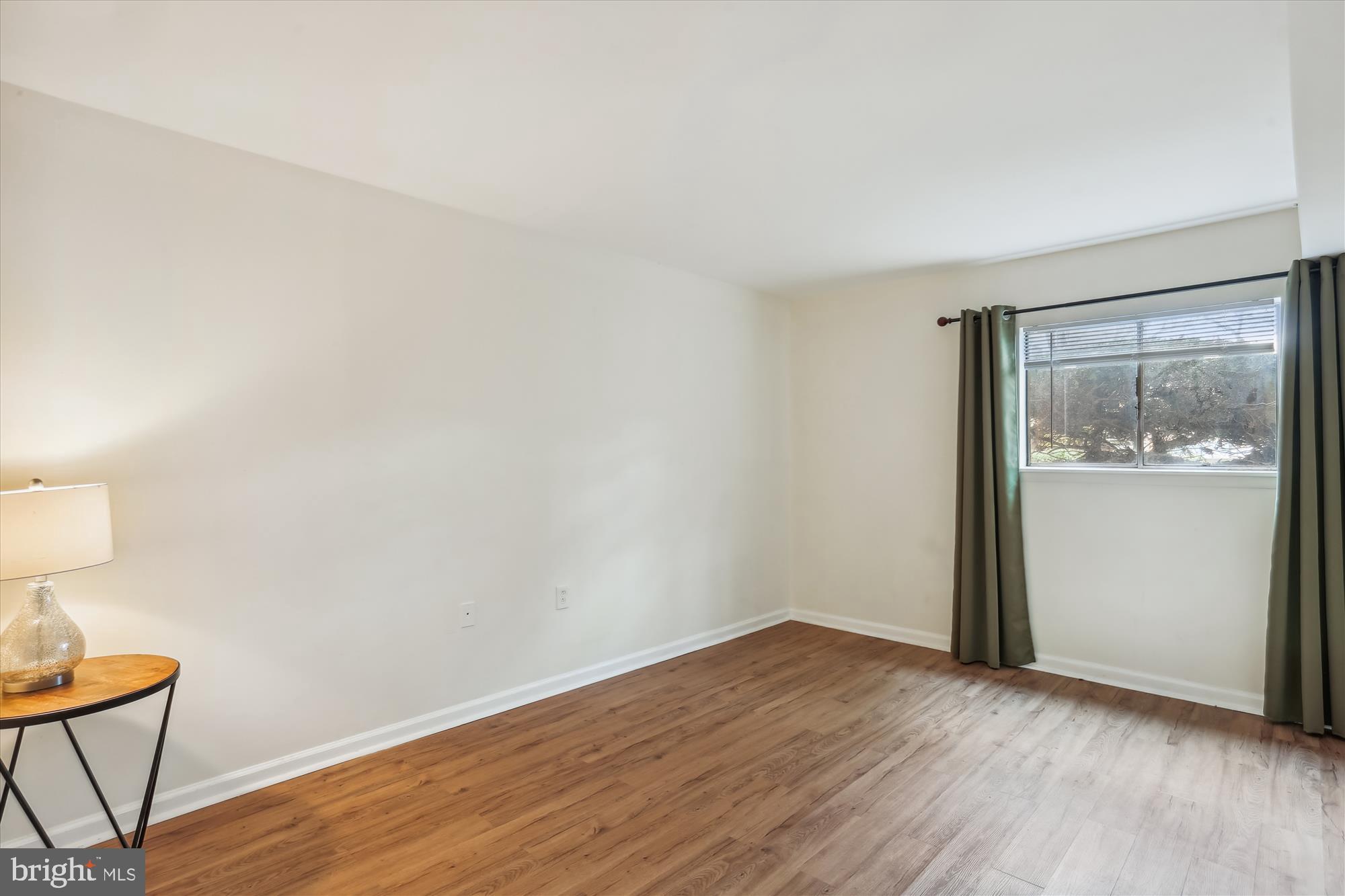 18612 Walkers Choice Road, Unit 1 Montgomery Village, MD 20886 - Photo 17 of 42 a view of an empty room with wooden floor and a window