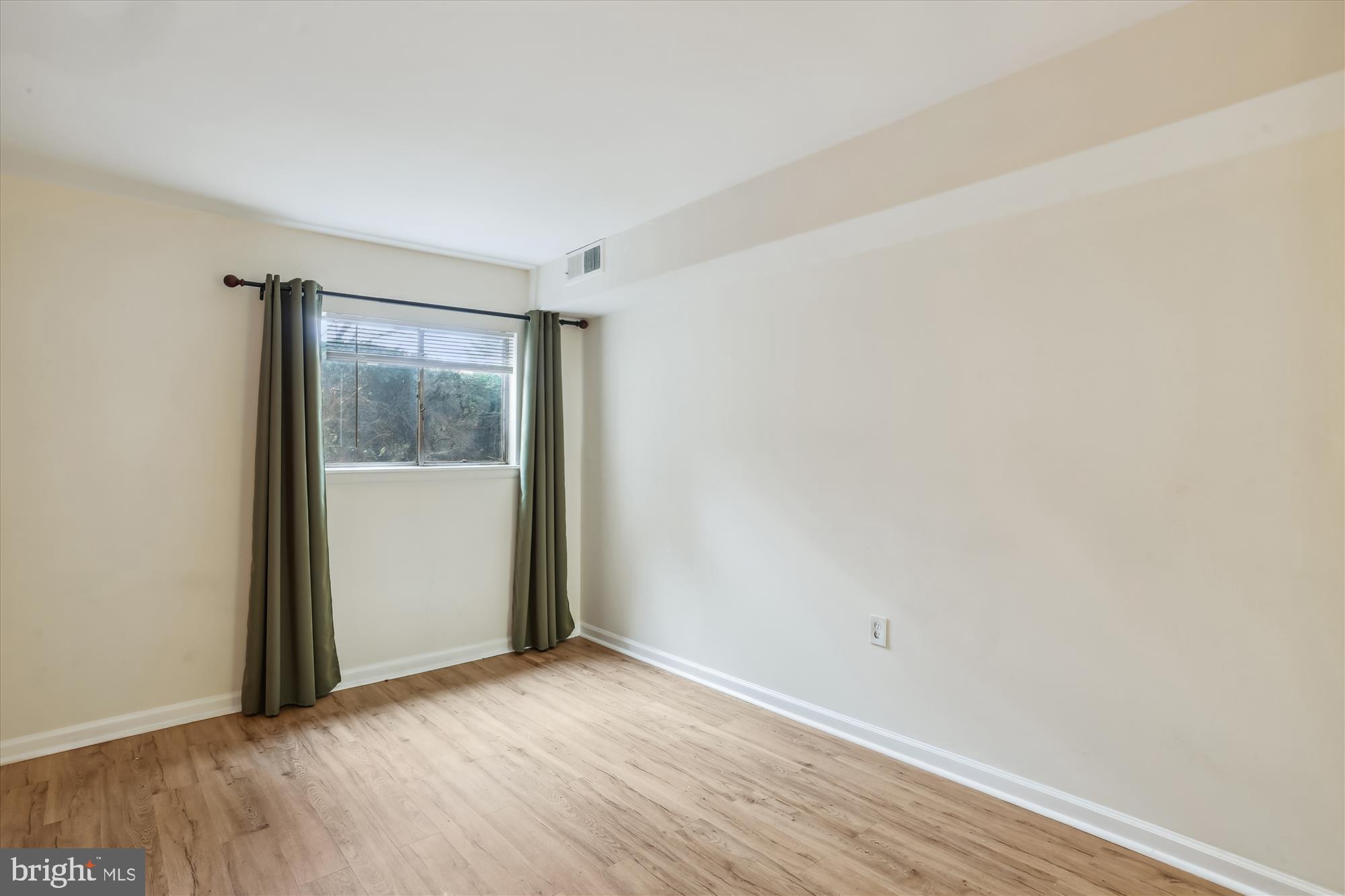 18612 Walkers Choice Road, Unit 1 Montgomery Village, MD 20886 - Photo 18 of 42 a view of an empty room with wooden floor and a window