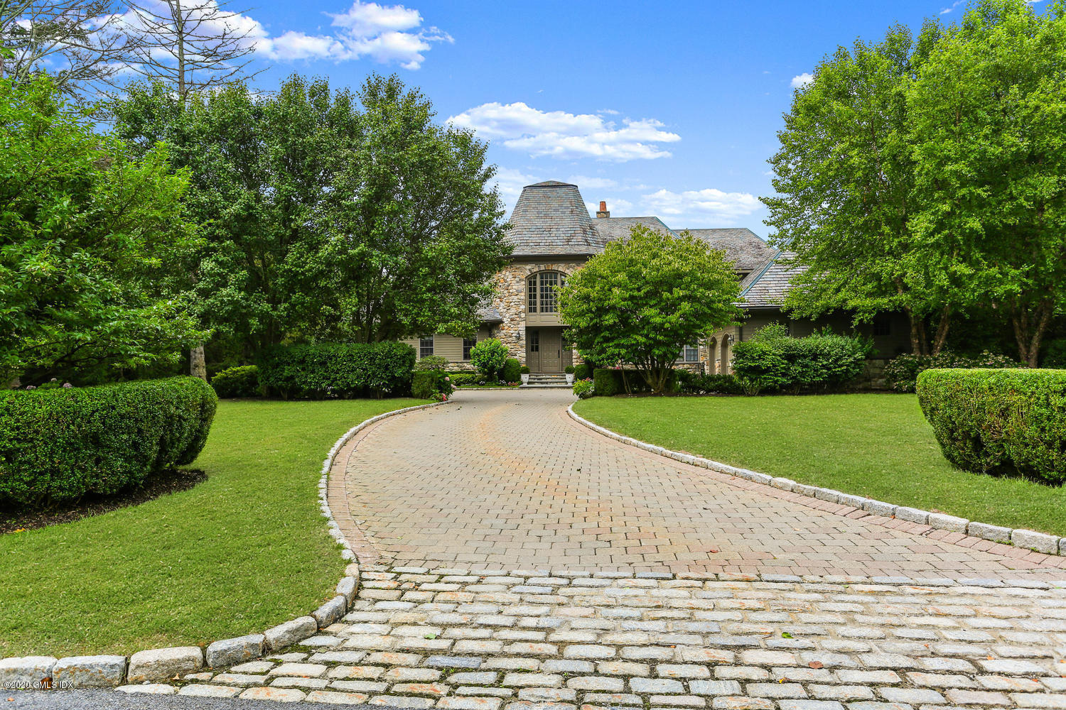 18 Chieftans Road Greenwich, CT 06831 - Photo 1 of 30 a front view of a house with a yard and potted plants