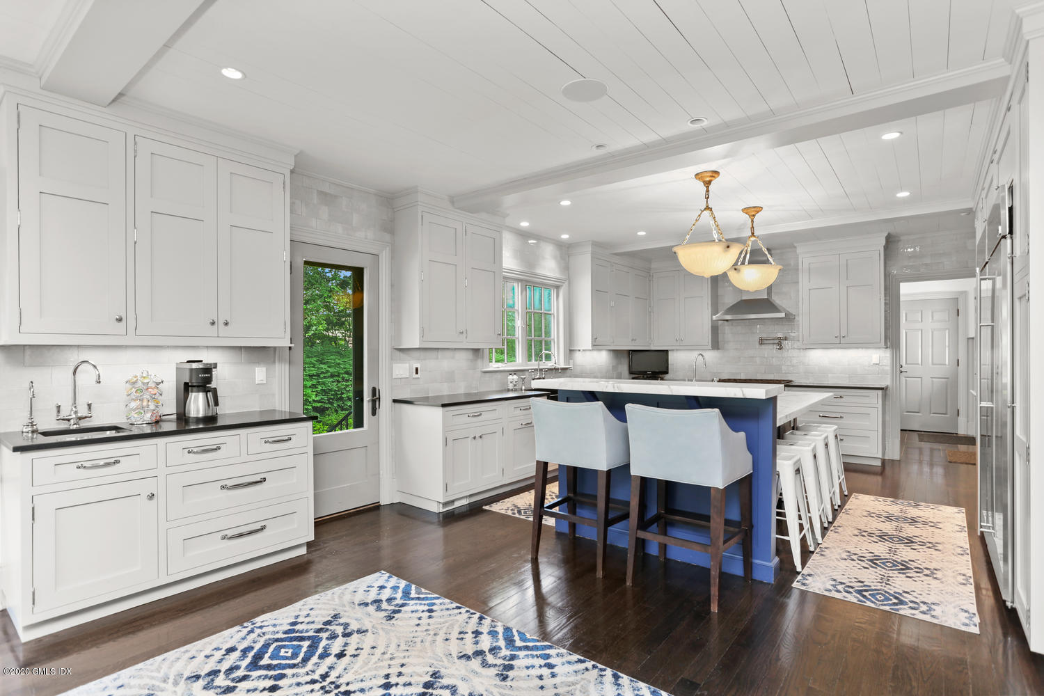 18 Chieftans Road Greenwich, CT 06831 - Photo 9 of 30 a kitchen with stainless steel appliances kitchen island granite countertop a table chairs and a refrigerator