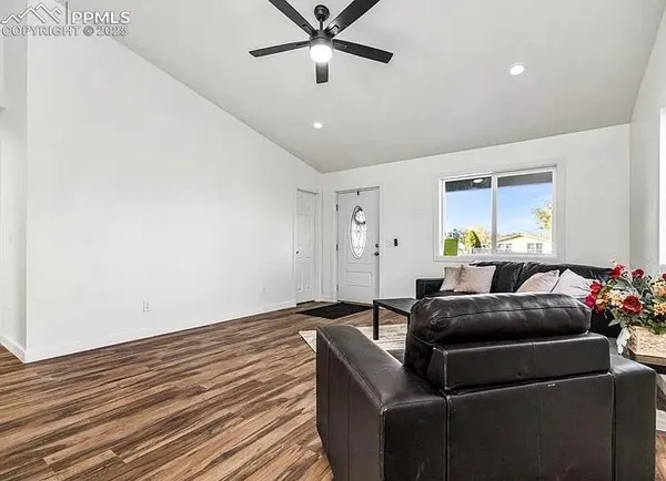 a living room with furniture and a ceiling fan