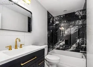 a bathroom with a sink toilet vanity and tub