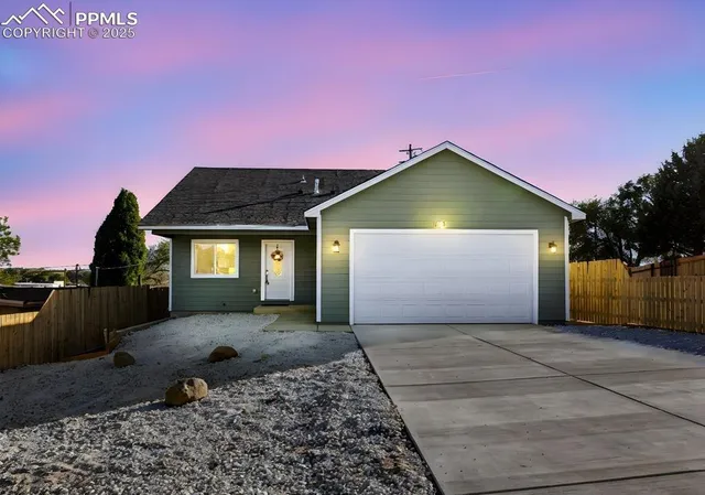 a front view of a house with a yard and potted plants