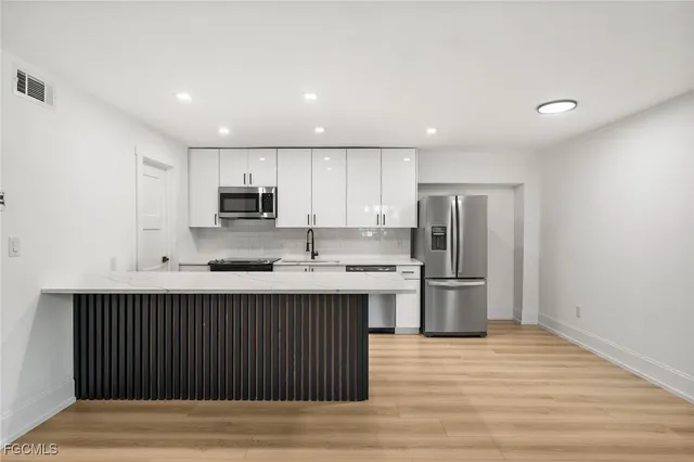 a kitchen with stainless steel appliances granite countertop a sink stove and refrigerator