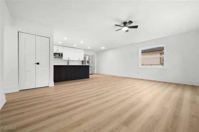 a view of empty room with wooden floor and window