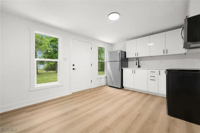 a view of a kitchen with a sink dishwasher oven and a window