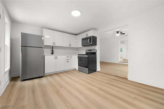 a view of kitchen with stainless steel appliances a refrigerator and a stove top oven