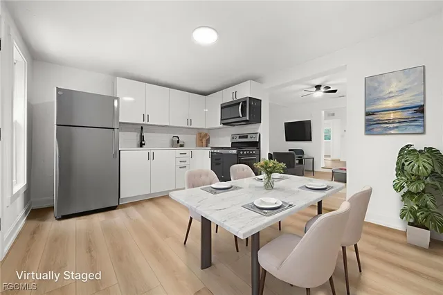 a kitchen with a table chairs and refrigerator
