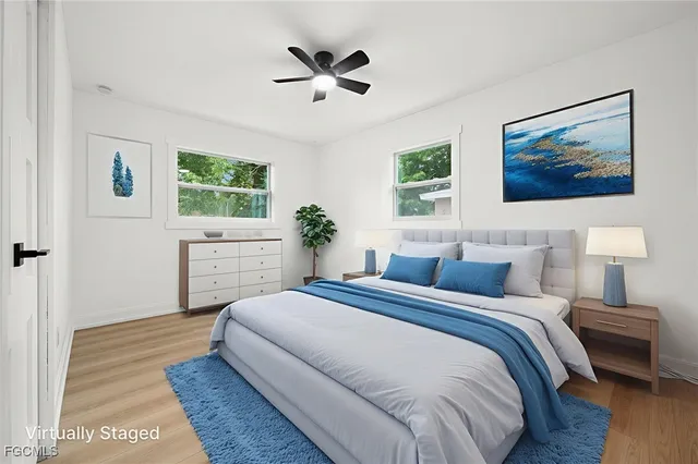 a bedroom with a large bed a chandelier and a potted plant