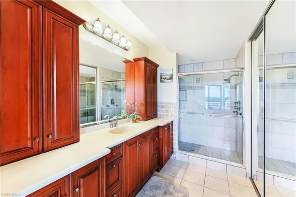 a bathroom with a sink mirror and shower