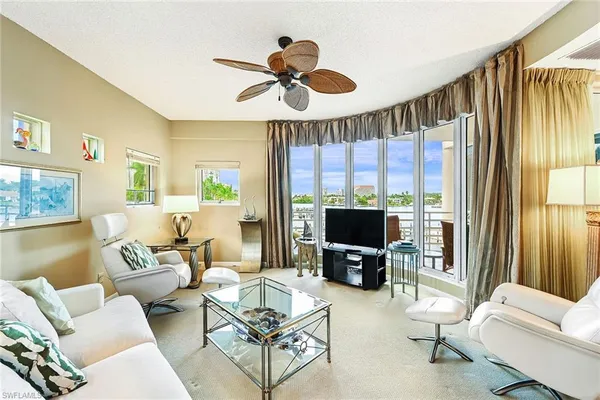 a living room with furniture a flat screen tv and a large window