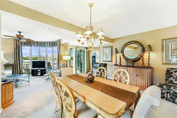 a view of a dining room with furniture a chandelier and wooden floor